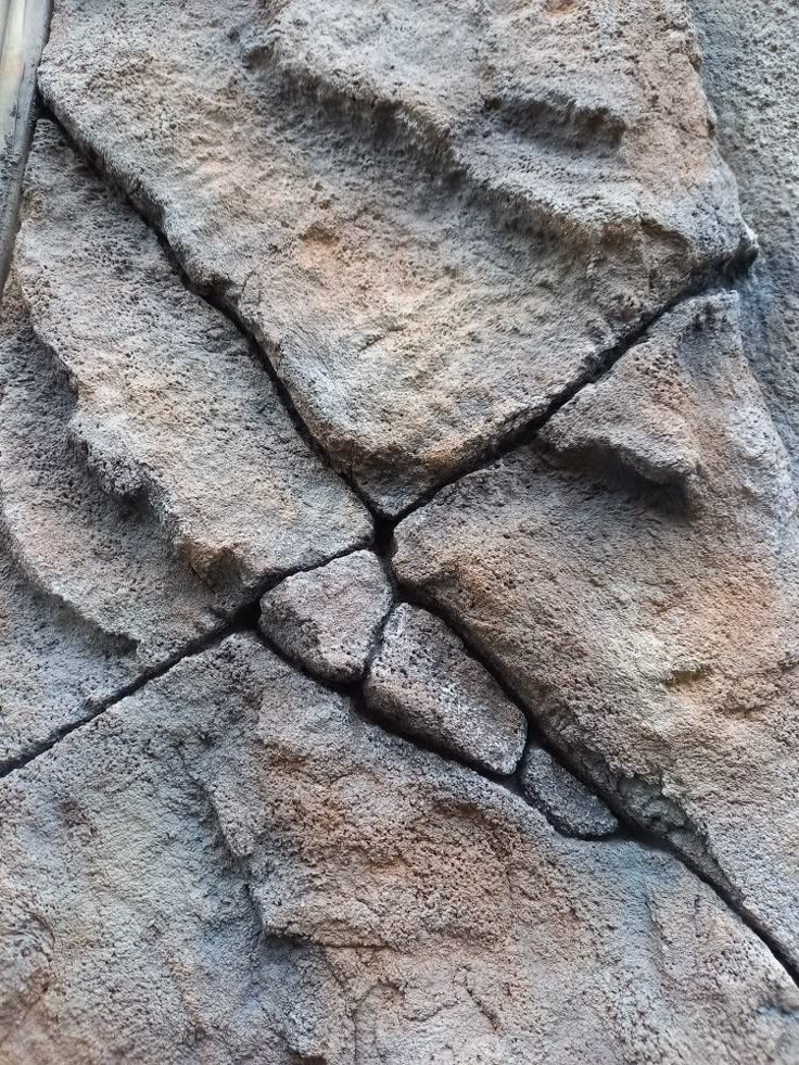 a bird sitting on top of a stone wall