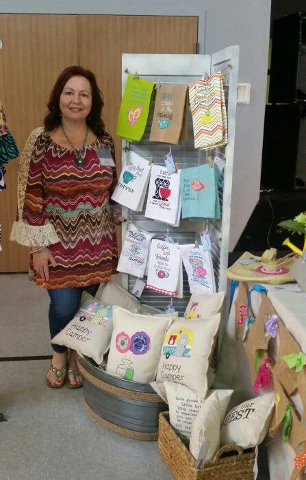 a woman standing next to a display case filled with cards and other items for sale