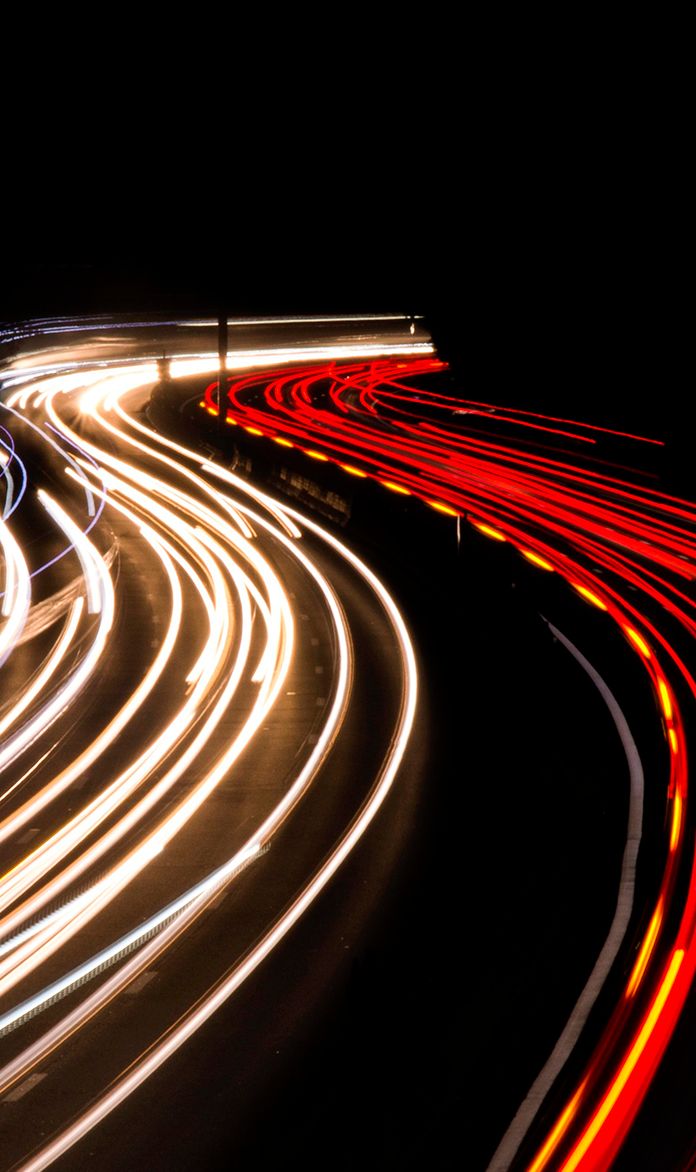 car lights streaking down the road at night