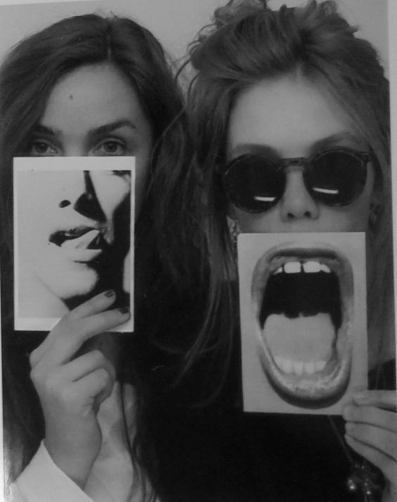 two women holding up photos with their mouths open