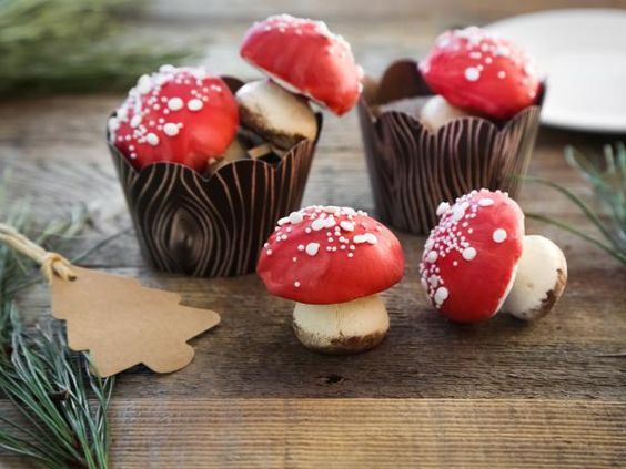 small red and white mushrooms sitting on top of a wooden table