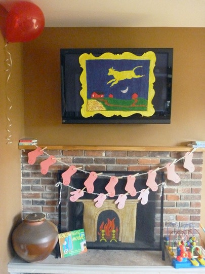 a living room with a fire place and decorations on the mantle, balloons in the air