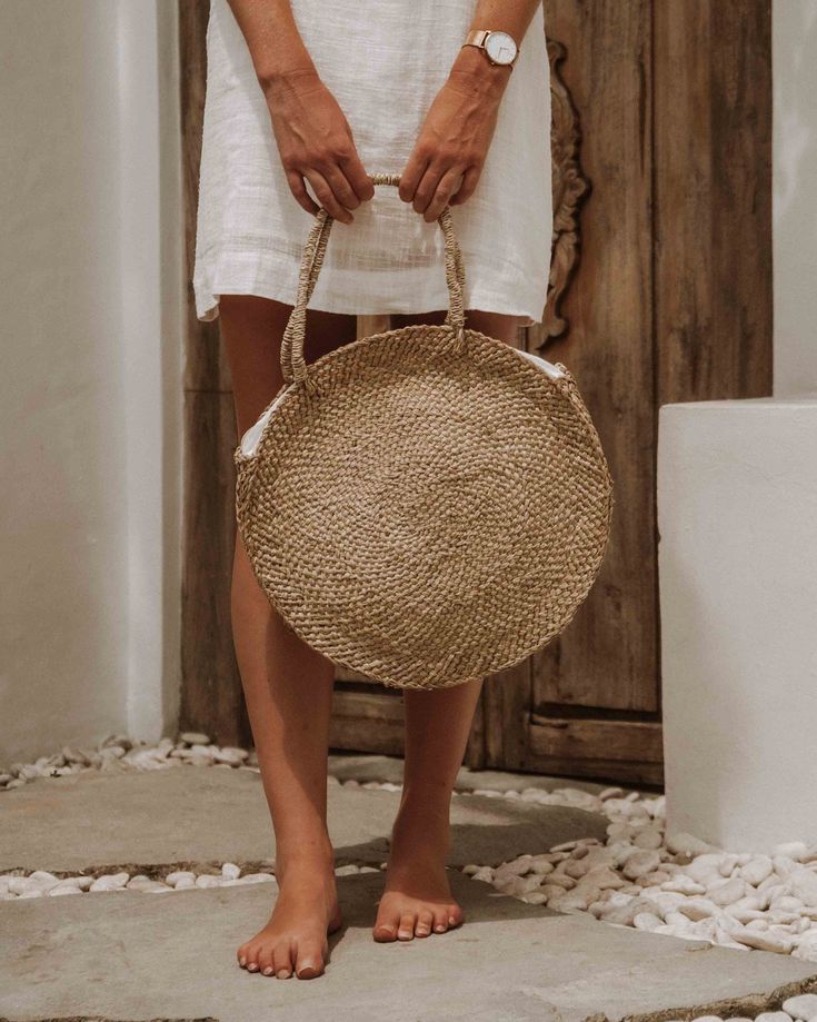 Experience the epitome of eco-conscious elegance with our Natural Grass Tote Bag, thoughtfully handcrafted to seamlessly house all your essentials while exuding an airy and environmentally-conscious charm. Crafted from authentic Balinese grass, each piece carries the essence of traditional island craftsmanship. Whether you're embarking on weekend getaways or leisurely strolls, this generously sized, round tote bag provides ample space for your belongings, ensuring you're always well-prepared in an eco-friendly manner. How it's Made Did you know it takes ONE MONTH to make one Rattan bag? That's because each of our Bali Bags is handcrafted from start to finish by artisans in Bali. ◖Made from a vine native to the volcanic foothills on the island of Bali. First, the stems are braided to create Chic Natural Beach Bag With Round Handle, Eco-friendly Natural Shoulder Bag For Vacation, Eco-friendly Ethically Sourced Straw Bag, Eco-friendly Lightweight Natural Bag, Ethically Sourced Bags For Vacation, Eco-friendly Lightweight Jute Beach Bag, Vacation Jute Bag With Round Handle, Lightweight Jute Bag In Natural Color, Eco-friendly Beige Straw Bag With Round Handle