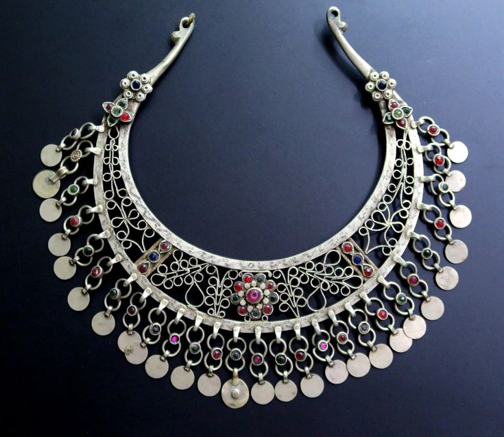 This ornate Afghan torc necklace was handcrafted during the mid-1900's for the nomadic Kuchi tribe of Central Asia. It is an old tribal jewelry neck-ring - not a new reproduction. MEASUREMENTS (1 inch = 2.54 cm): Neckline circumference = 17 inches, including gap Front Drop = 3 inches (distance between upper/lower edges at center front) Necklace width = 8 inches Weight = 7.4 oz Shipping Weight = 14 oz TM image library 9-10-2020 The torc is a distinctive style of neck-ring choker-necklace that has Traditional One-of-a-kind Necklace For Festival, Traditional Ceremonial Necklaces, Multicolor Bohemian Jewelry With Intricate Design, Traditional One Of A Kind Necklaces For Ceremonial Occasions, Traditional One-of-a-kind Necklaces For Ceremonial Occasions, Traditional Round Necklaces For Festivals, Bohemian Round Ceremonial Necklace, Traditional Pendant Necklace With Historical Design, Bohemian Round Necklace For Ceremonial Occasions