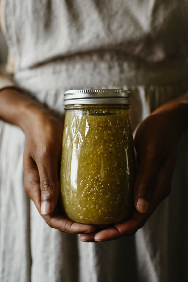 a person holding a jar of food in their hands