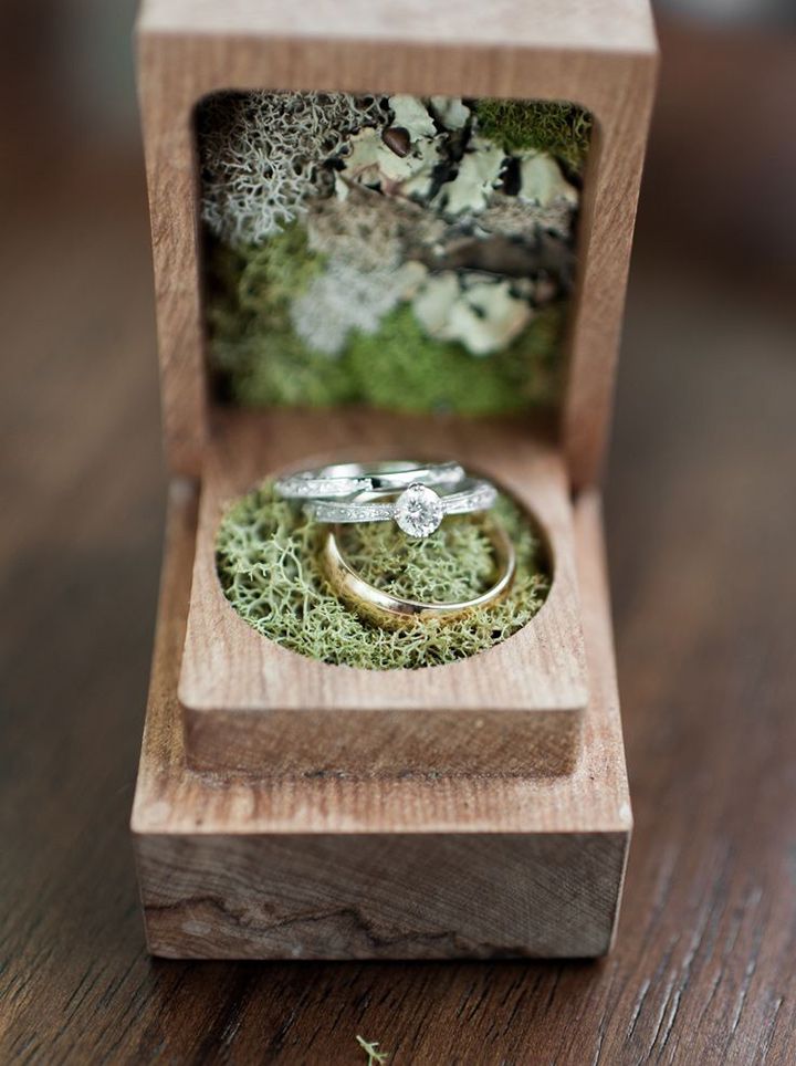 an engagement ring in a wooden box with moss