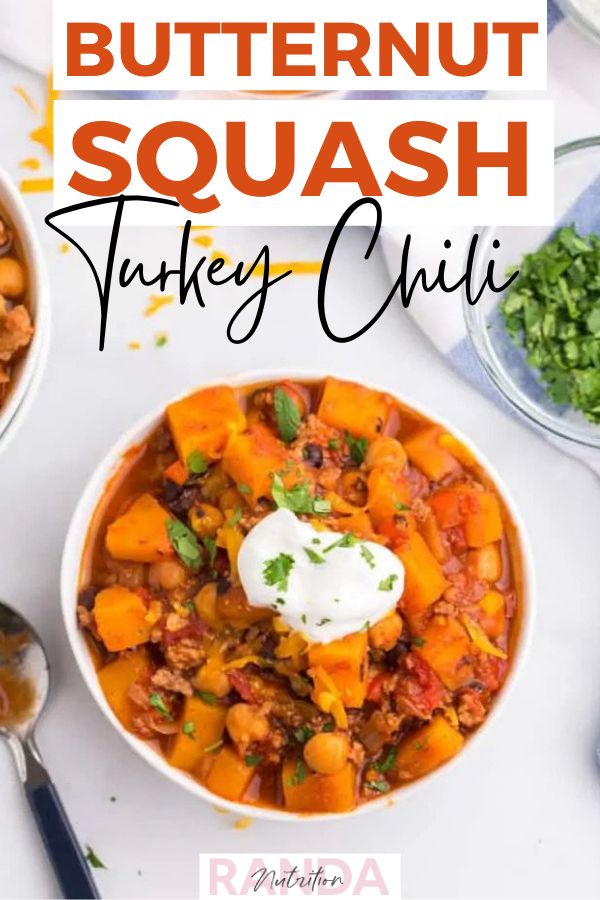 two bowls of butternut squash chili with sour cream and cilantro on the side