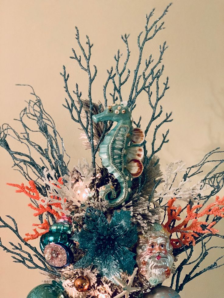 a vase filled with seahorses and coral on top of a table