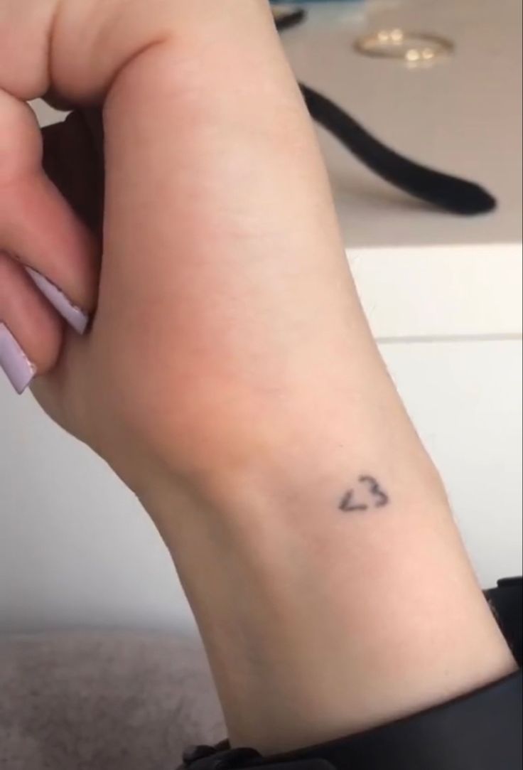 a woman's foot with a heart tattoo on it