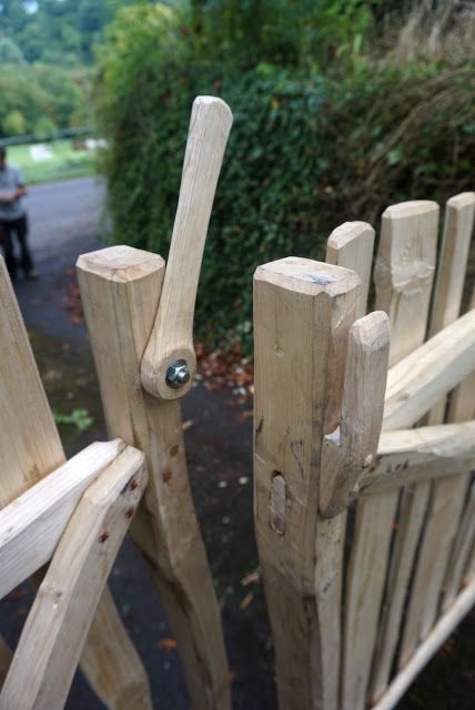 a wooden bench sitting in the middle of a park next to a person on a motor scooter