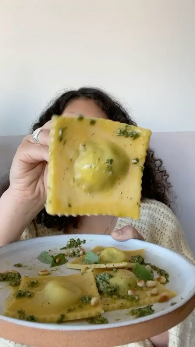 a woman holding up a piece of food in front of her face