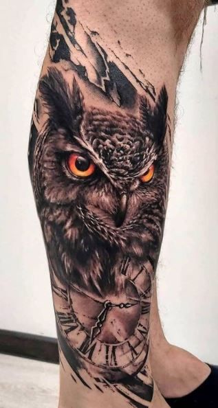 an owl with orange eyes and clock tattoo on the leg is seen in this photo