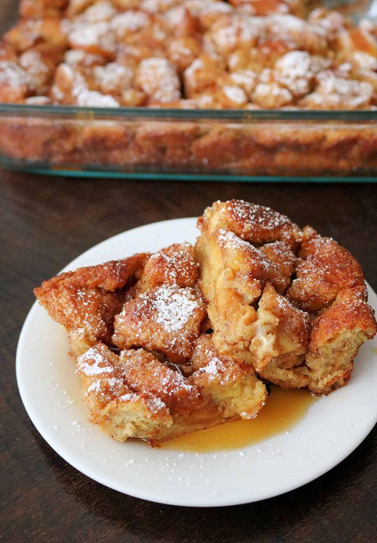 two pieces of dessert sitting on top of a plate next to a casserole dish