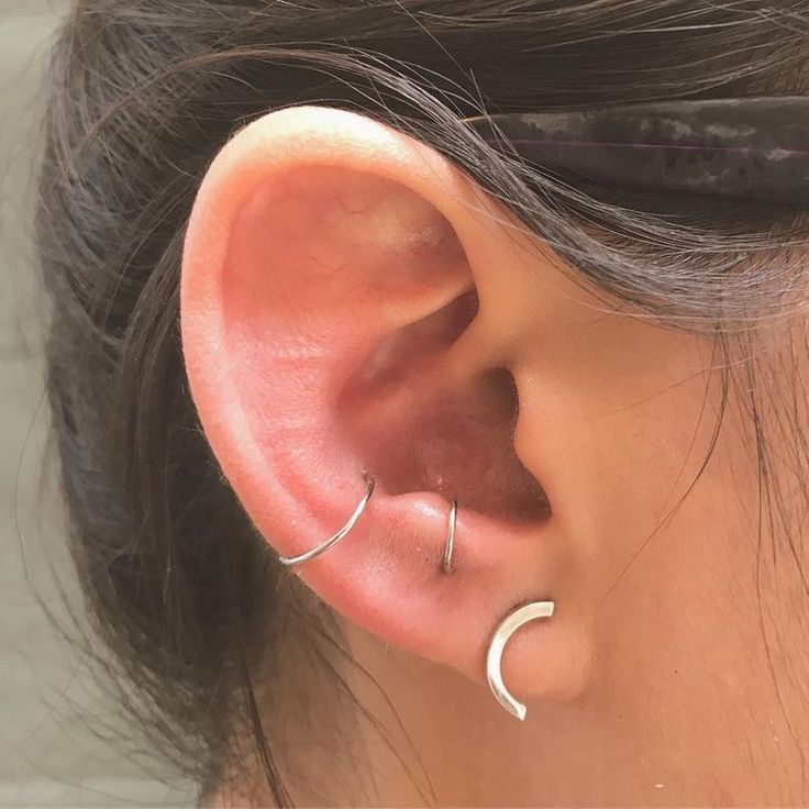 a close up of a person's ear with two small hoops on it