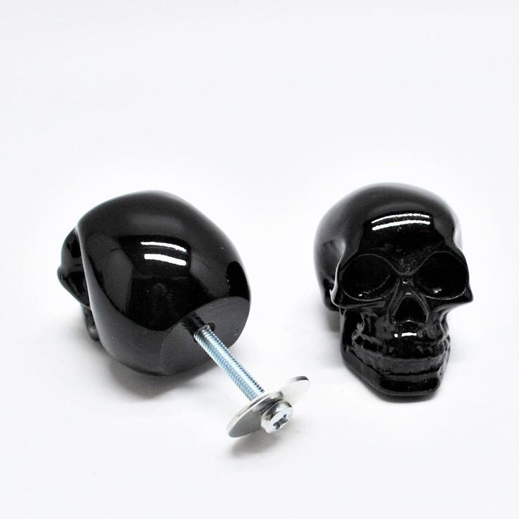 a pair of black skull head plugs are shown with screws on the end