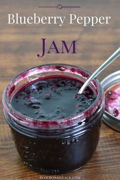 blueberry pepper jam in a glass jar with a spoon on the table next to it