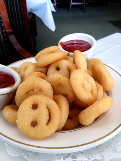 some onion rings are on a plate with ketchup