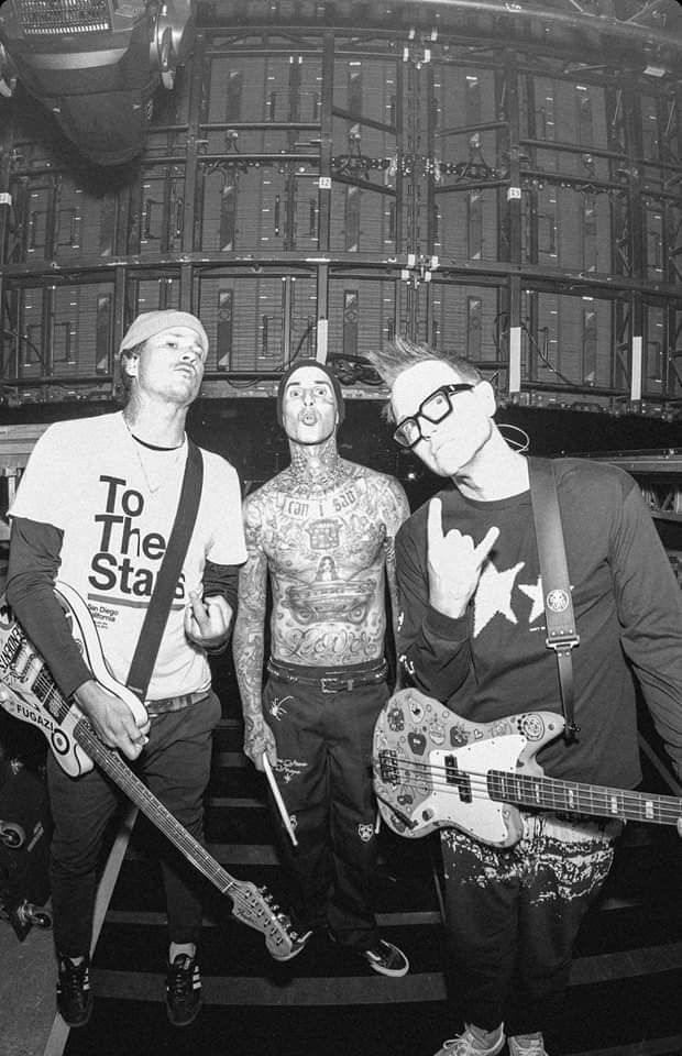 three men standing next to each other with guitars