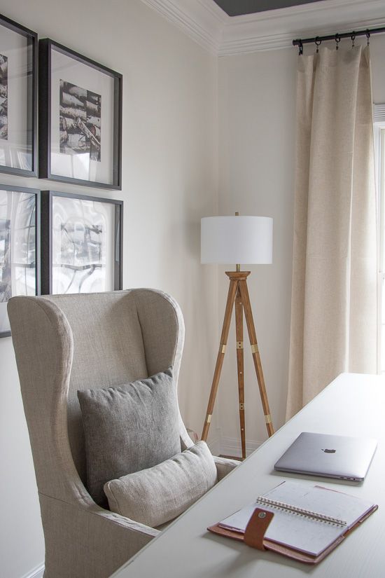 a chair sitting in front of a window next to a table with a laptop on it