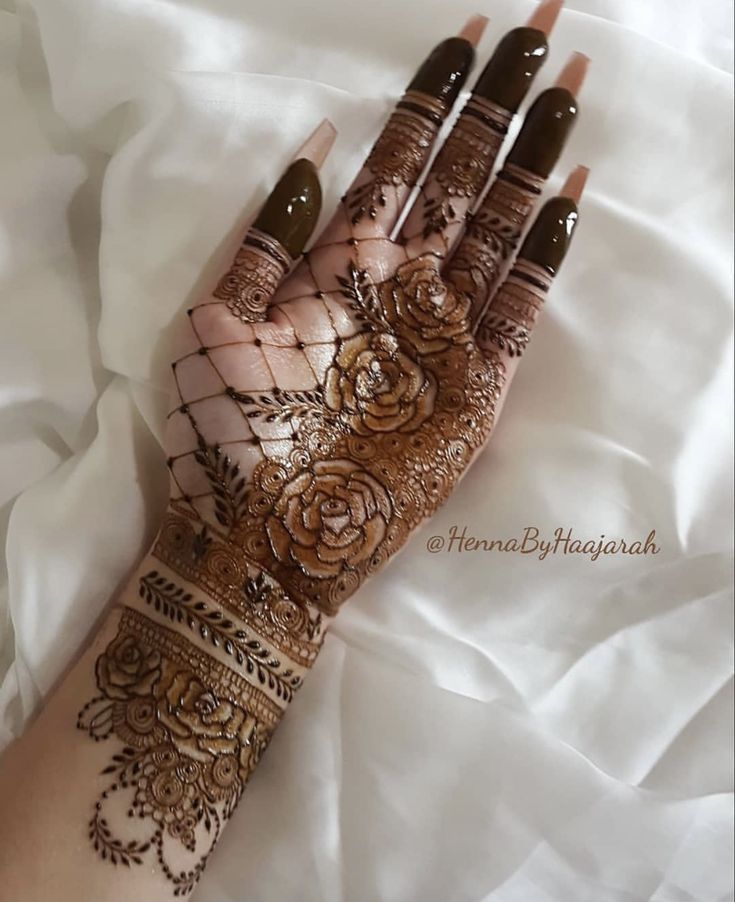 hendi tattoos on the hand of a woman with brown and white flowers painted on it