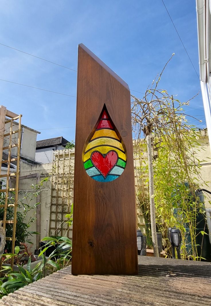 Wood and glass garden Sculpture (Mini Rainbow tear drop heart Stained glass window) Solid timber sculpture shaped and finished in dark brown stain, with colourful tear drop stained glass window - designed to be displayed indoors or outside. Display sculpture on any level surface. Any where indoors or outdoors, In the garden or placed on decking. Sculptures topped with wave design and a in-set stained glass window.  Stained glass window constructed using all traditional methods.  A beautiful sigh Tiffany Stained Glass Windows, Heart Sculpture, Pride Colors, Tiffany Stained Glass, Glass Garden Art, Stained Glass Diy, Stained Glass Designs, Glass Garden, Stained Glass Window