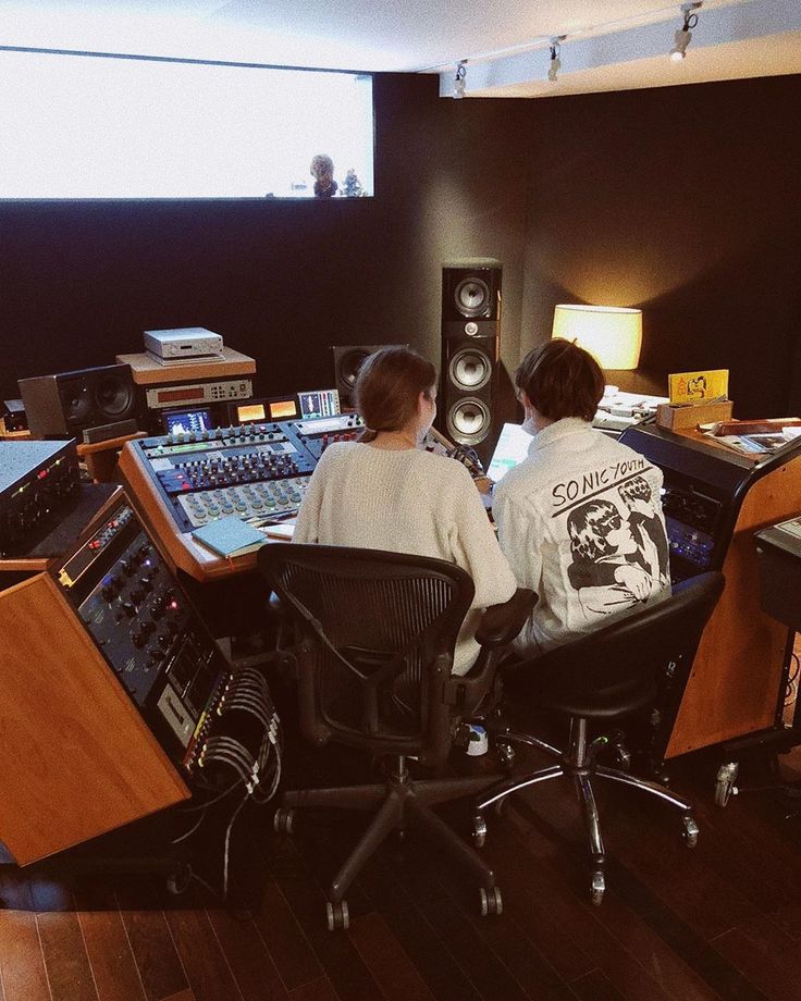 two people sitting in front of sound mixing equipment