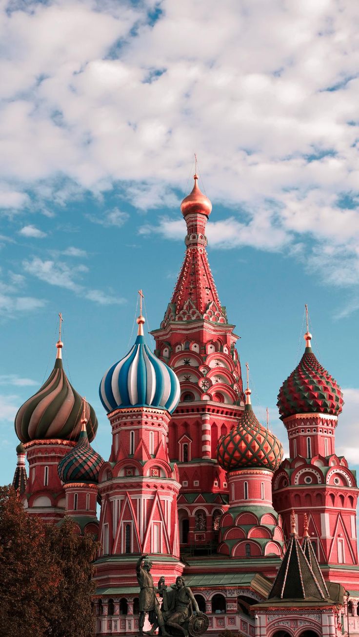 an ornate building with many domes on it's sides and a statue in the foreground