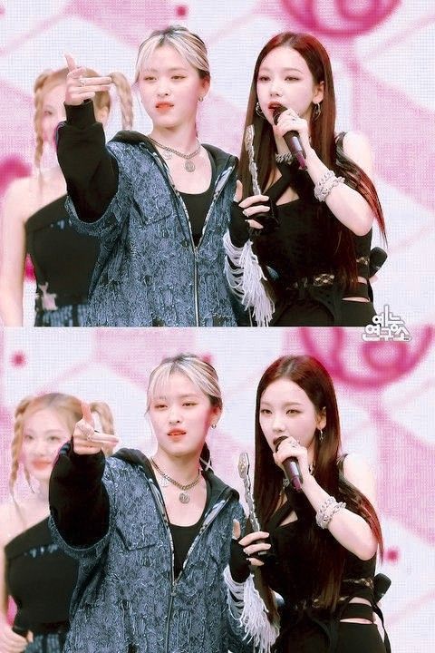 two girls singing into microphones in front of a pink background