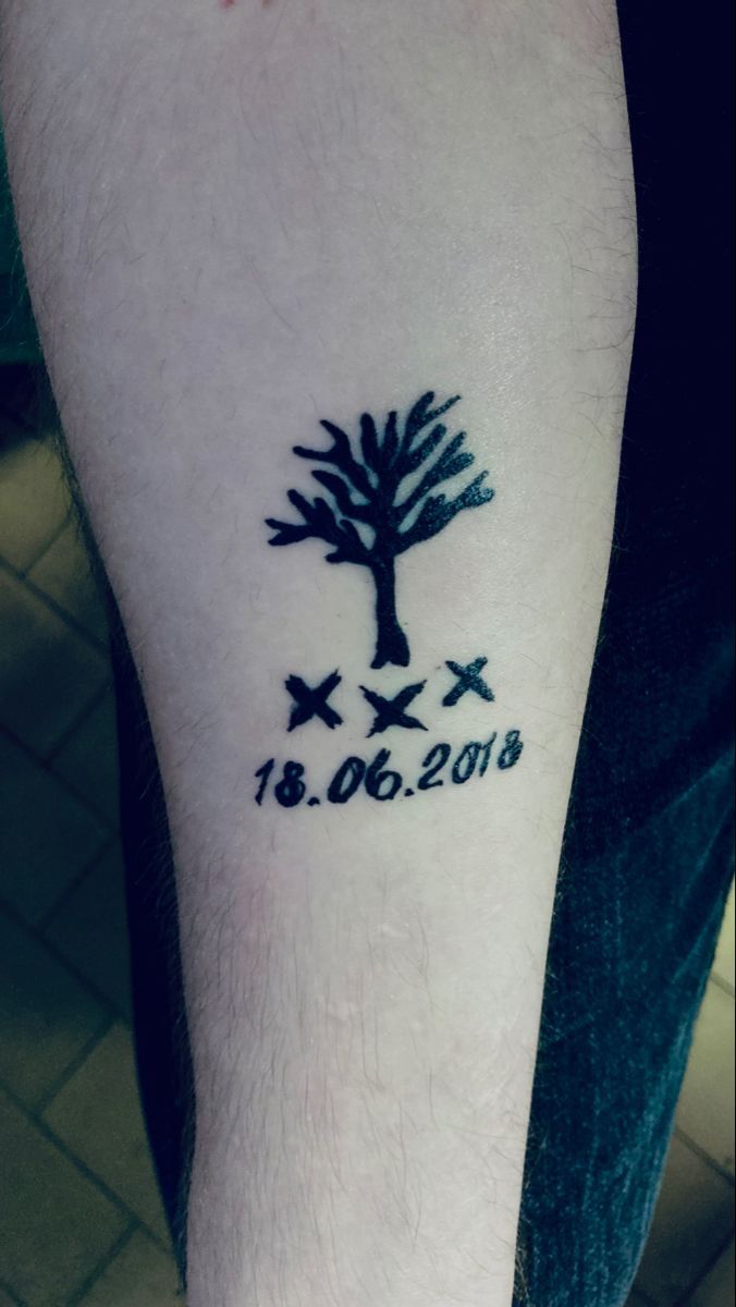 a man's arm with a tree and stars tattoo on the left side of his leg