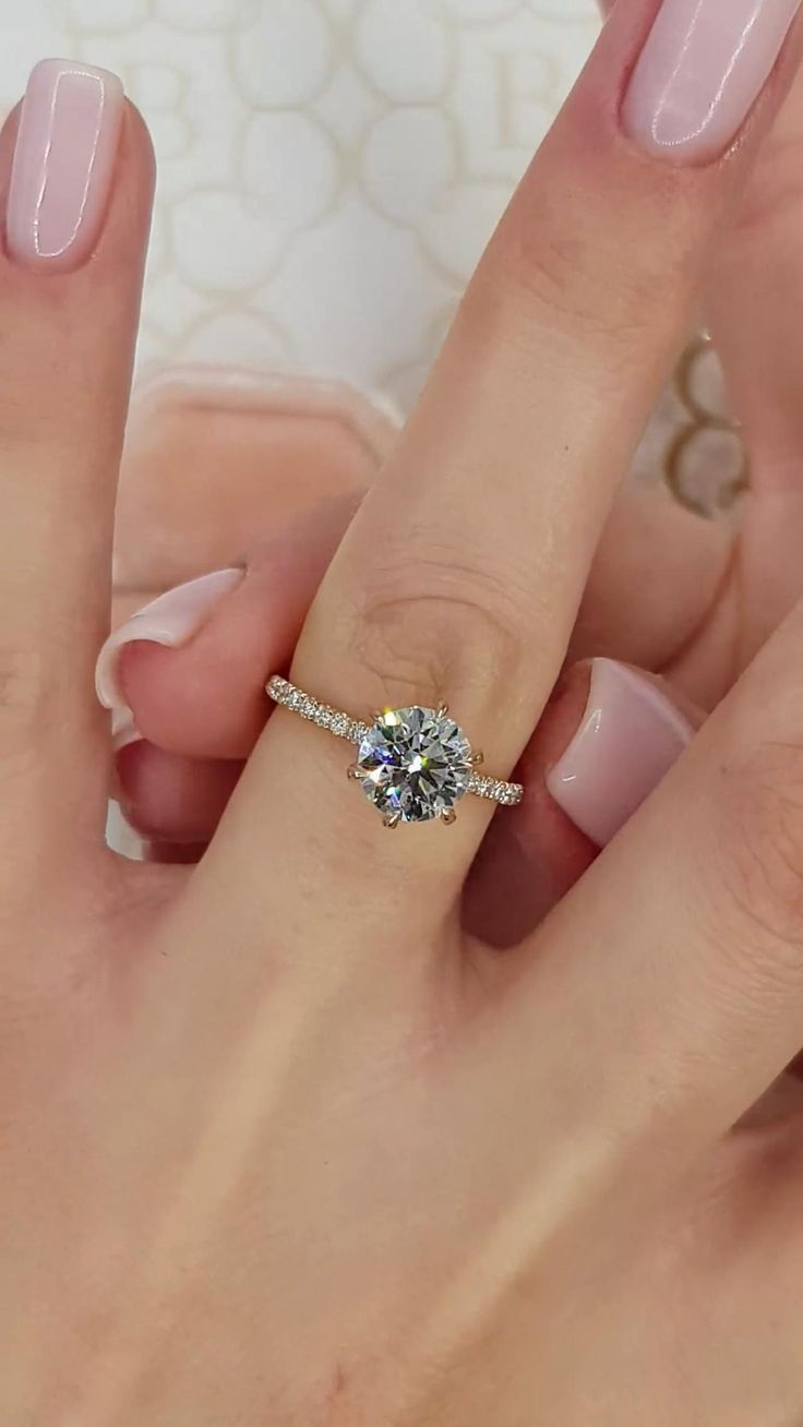 a woman's hand with a ring on it and a diamond in the middle