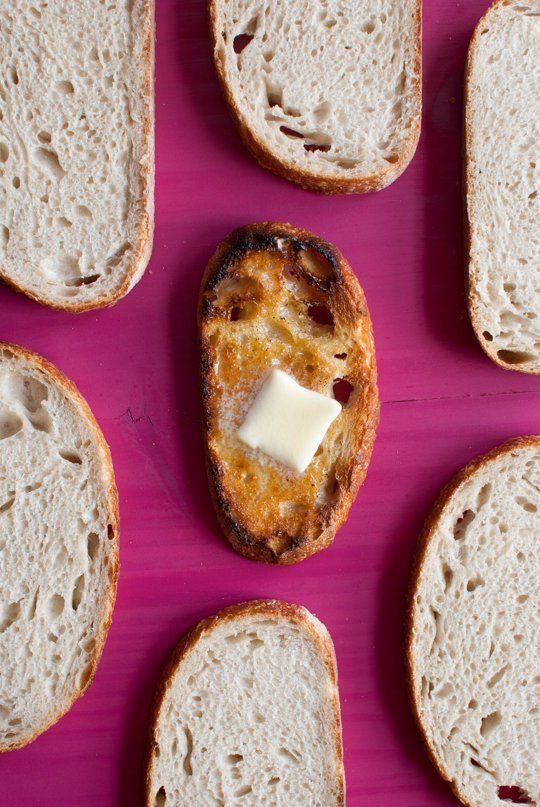 several pieces of bread with cheese on them sitting on a pink surface next to each other