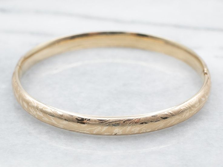 "The details on this vintage 14-karat gold bangle are simply stunning!  Intricate scrolling botanical designs are engraved in warm yellow gold, covering the entire bracelet. Beautiful on its own or layered with other bracelets this piece is perfect for day or evening wear. Metal: 14K Yellow Gold Width: 6.3 mm Inside Circumference: 6 1/2 Inches Marks: \"JW 14K\" Stamped on the inside band To view a video of this piece check out the link below: https://vimeo.com/831970277 SKU #: A26074 Each piece Antique Round 14k Gold Bangle, Antique 14k Gold Bangle Bracelet, Antique 14k Gold Round Bangle, Heirloom 14k Gold Round Bracelets, Heirloom 14k Gold Bracelets, Heirloom 14k Gold Round Bracelet, Heirloom 14k Gold Wedding Bracelet, Heirloom Wedding Bracelet Stamped 14k, Heirloom Style Engraved Bangle For Formal Occasions