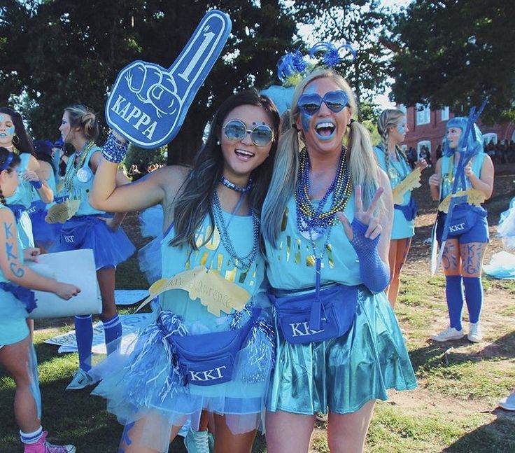 two girls dressed in blue posing for the camera with their arms around each other and smiling