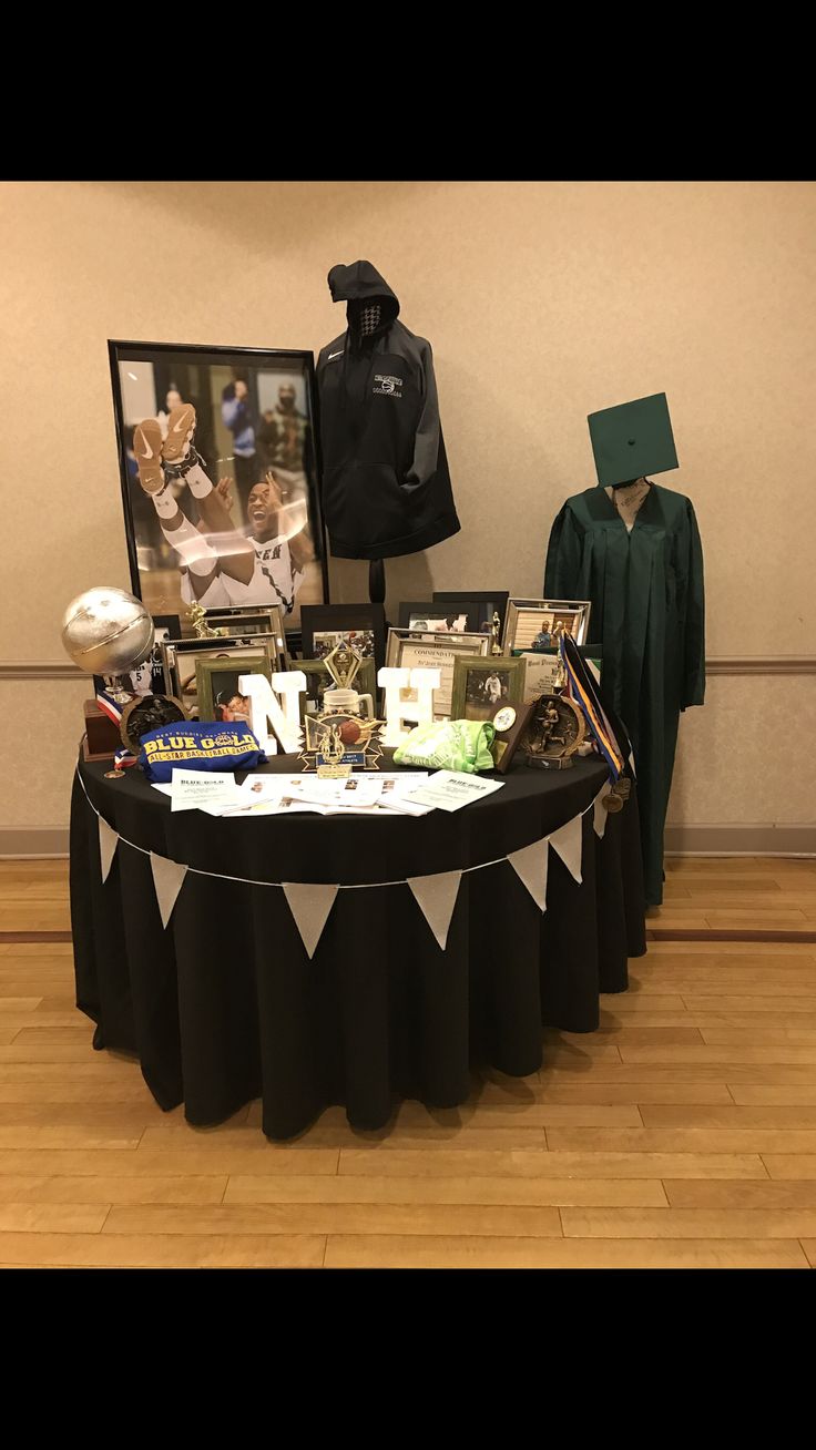 the table is set up in front of two mannequins wearing graduation caps and gowns