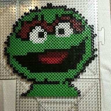 an image of a pixel art piece made out of legos and plastic beads on display