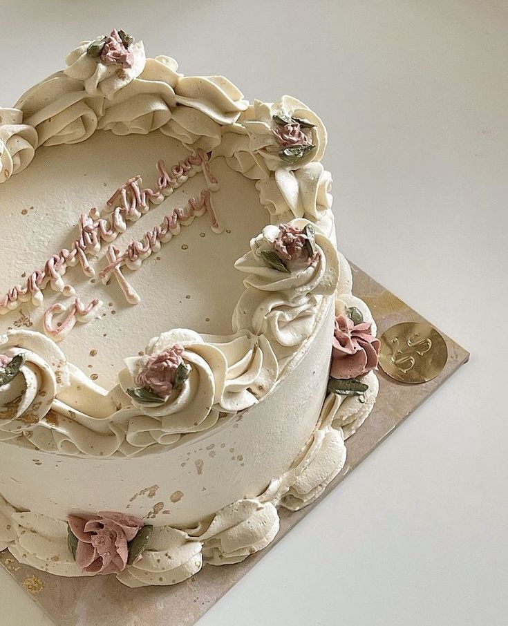 a birthday cake with white frosting and pink flowers