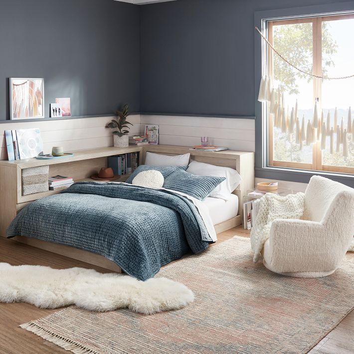 a bed room with a neatly made bed next to a window and a rug on the floor