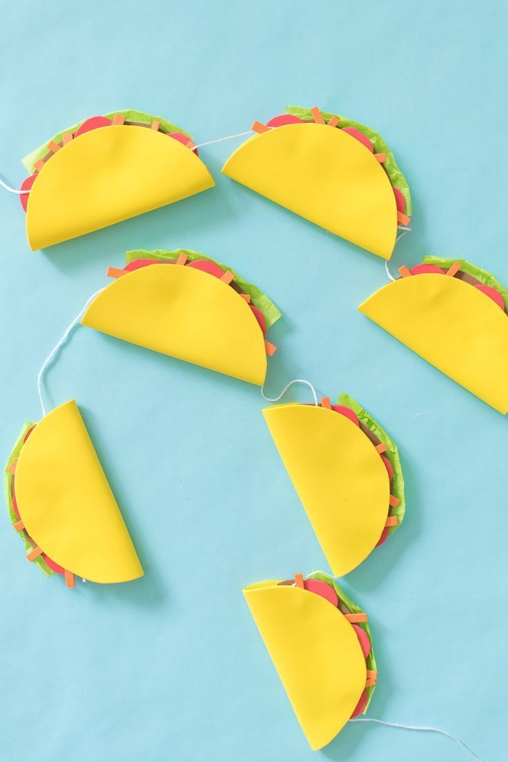 paper tacos are hanging from string on a blue background