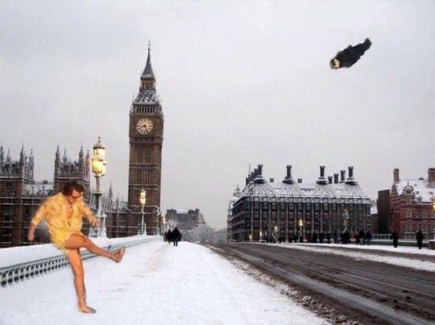 a woman sitting on the edge of a bridge in front of big ben