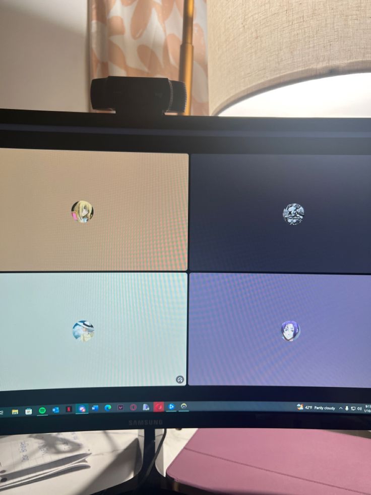 a computer monitor with four different colored screens on it's screen and a lamp in the background