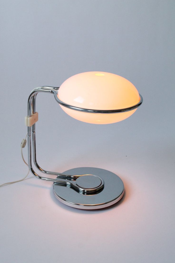 a table lamp that is on top of a white surface and has a light bulb attached to it