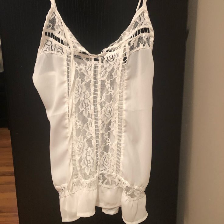 White Lace Tank. Never Worn. Has See Through Lace Going Down Center. Can Be Worn Alone Or With Cami. White V-neck Camisole For Vacation, White Lace Summer Blouse, Elegant Lace Camisole For Beach, Chic Lace Top Camisole For Vacation, White Lace Top Camisole For Vacation, Elegant White Tank Top For Beach, Summer Blouse With Spaghetti Straps For Vacation, Chic Beach Camisole With Lace Top, White V-neck Camisole For Beach