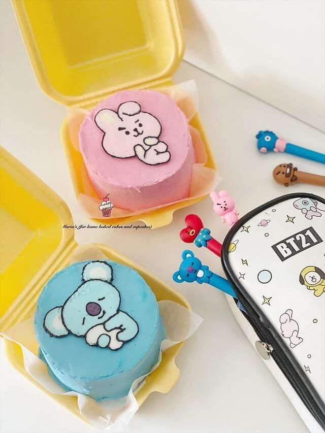 there are two small cakes in plastic containers on the table with other items around them