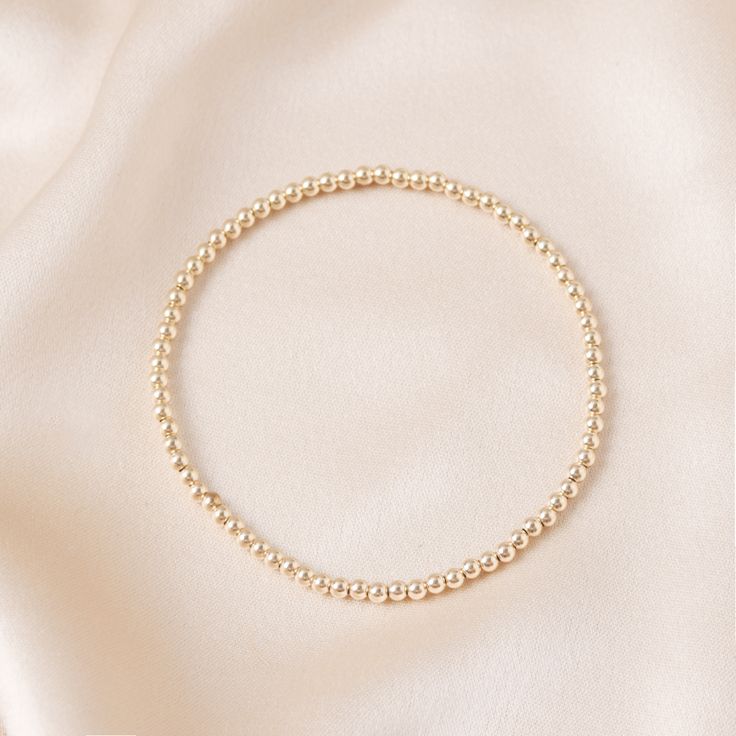 This stretchy gold ball bracelet is made of 14k gold filled beads, and is the perfect addition to any outfit. Whether you're dressing up for a special occasion or just want to add a touch of luxury to your everyday look, this bracelet is sure to make a statement. Swim, sweat, and sleep in it without a worry in the world. Gold 14k Gold-filled Round Beads Pearl Bracelet, Elegant Gold Beaded Bracelets With Ball Chain, Dainty Beaded Bracelets With Ball Chain, Elegant Gold Ball Chain Bracelet, Elegant 14k Gold-filled Bracelet With Round Beads, Gold Stretch Bracelet With 8mm Beads For Party, Gold Bracelets With 8mm Beads For Party, Party Gold Bracelet With 8mm Beads, Elegant Gold Bracelet With Hypoallergenic Round Beads