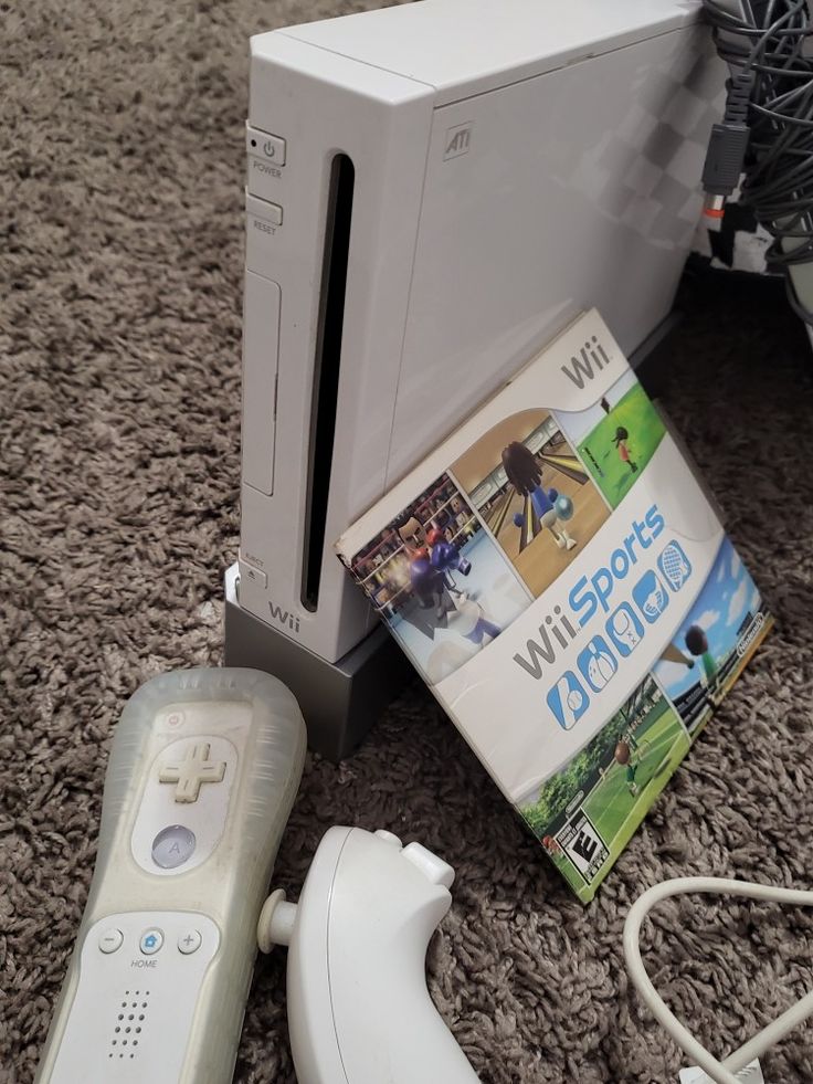 a wii game system sitting on the floor next to other items