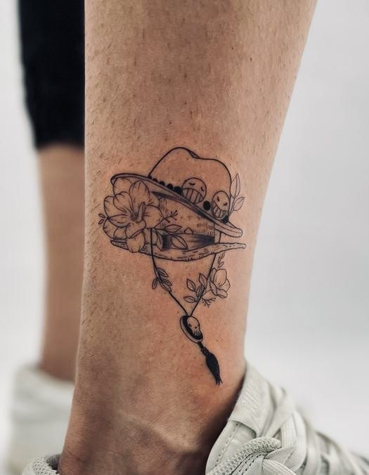 a woman's foot with a tattoo on it and flowers in the shape of a heart