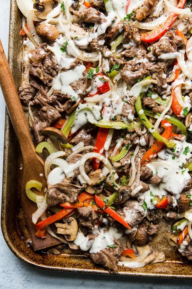 a casserole dish with beef, peppers, onions and mushrooms