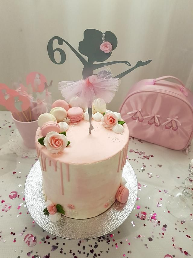 there is a cake with pink frosting and flowers on it