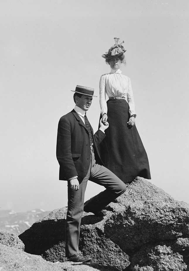 an old black and white photo of two people on top of a mountain