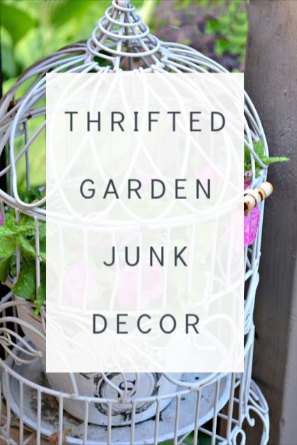 a birdcage filled with plants sitting on top of a wooden table